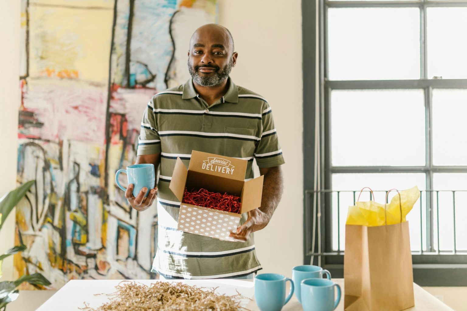 A Kenyan insurance agent in a bright Nairobi office, holding a parcel and a cup