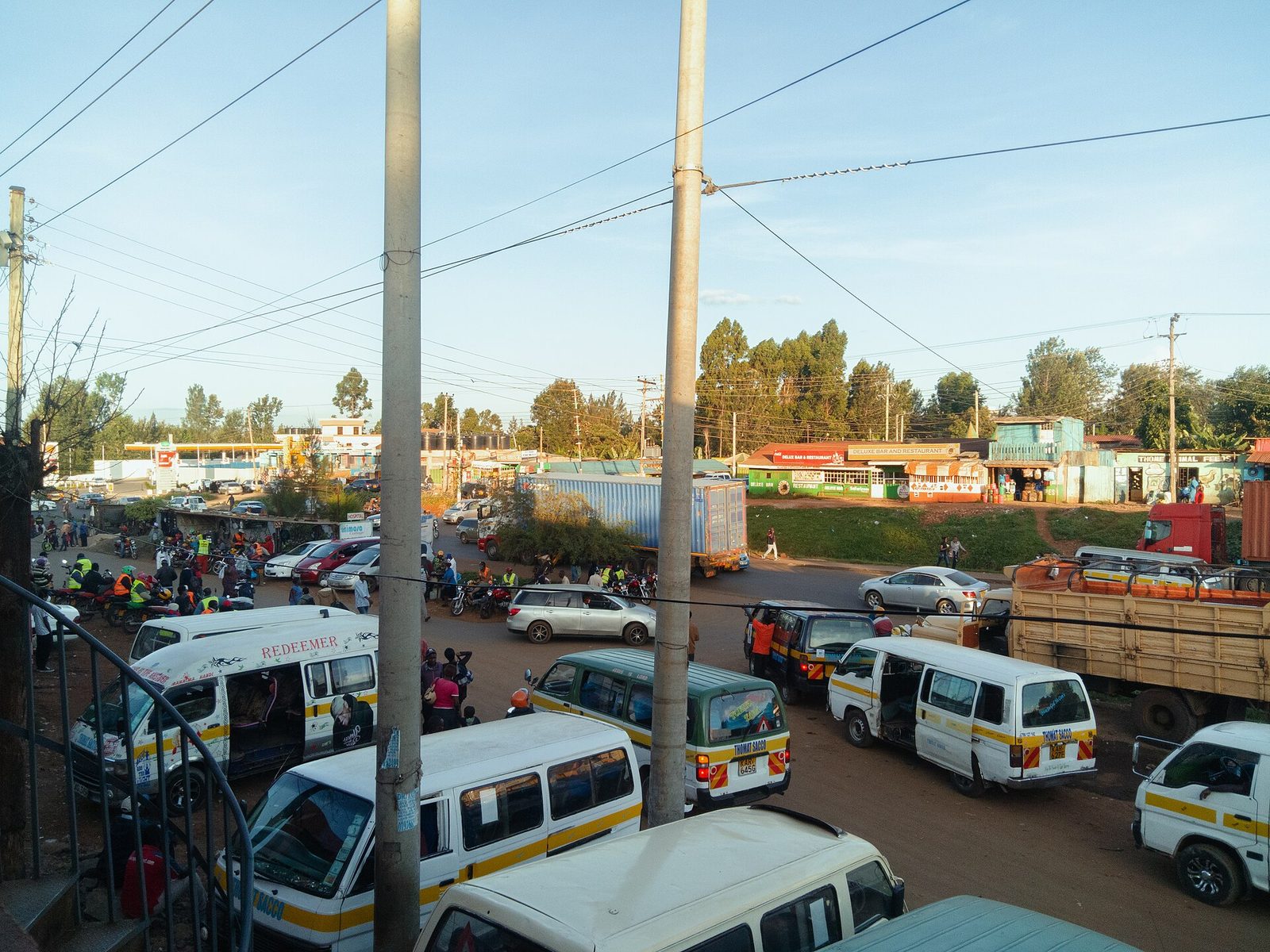 Buses and matatus parked at a stage at sunset