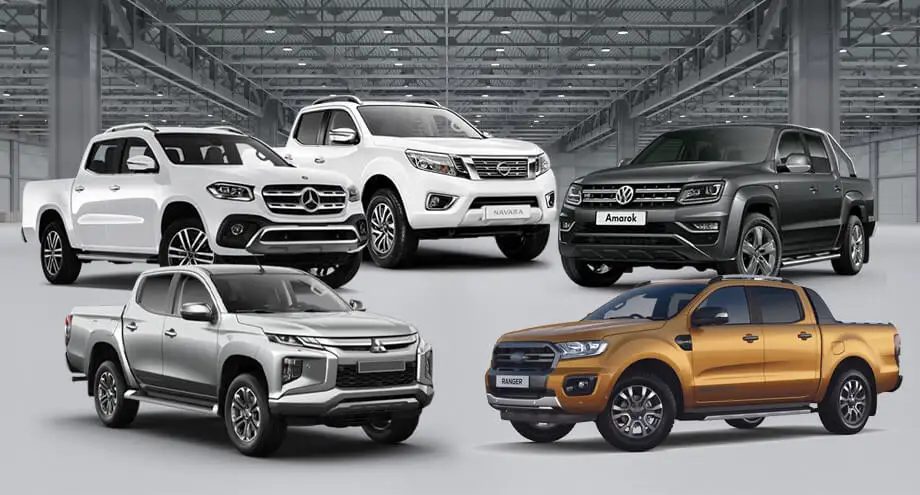 A row of white commercial pickup trucks parked in a yard