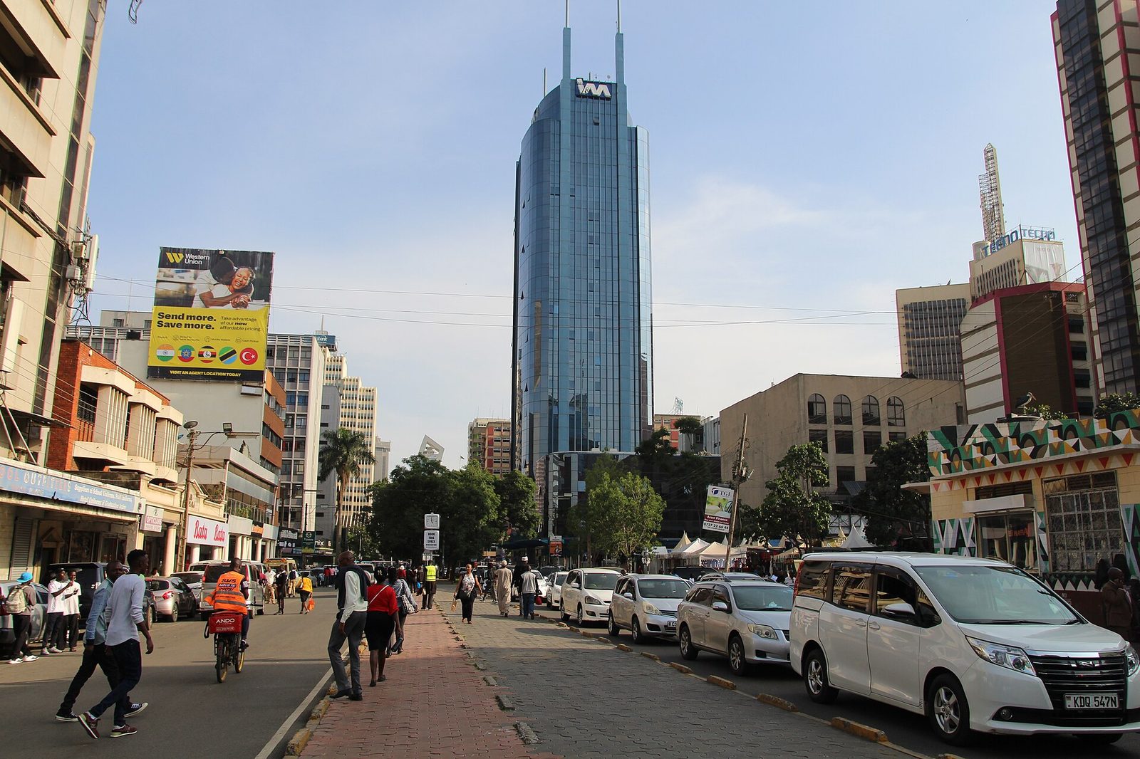 Pedestrians and cars on a busy street in Nairobi's city centre