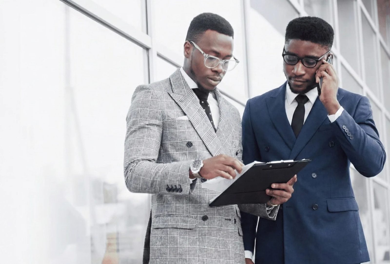 Two Kenyan professionals reviewing insurance options together on a tablet