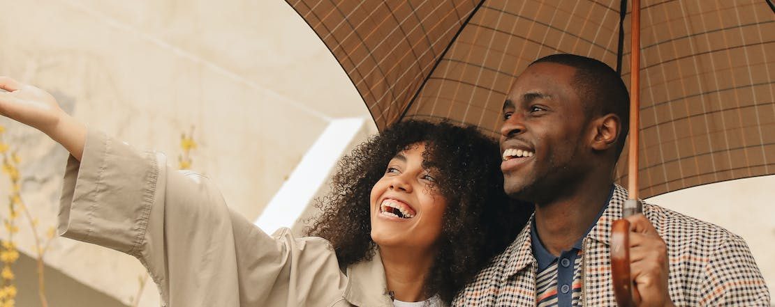 A smiling Kenyan couple sharing an umbrella